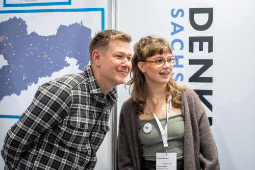 Ostmodern Team vor Denkmalnetz Sachsen Logo