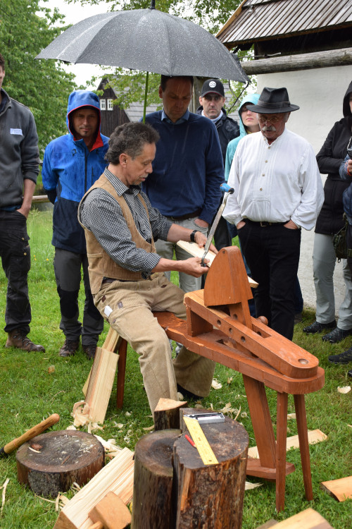 Mann führt Holzschindeltechnik vor